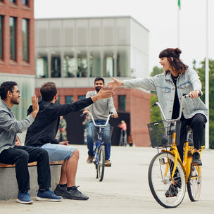 Ihmiset tervehtivät iloisesti Korkeakouluaukiolla