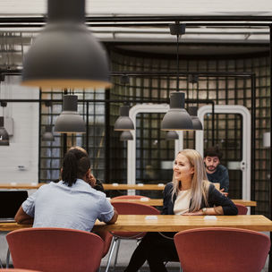 Ihmisiä keskustelemassa pöydän ääressä